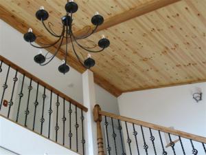 ロートアイアンの質感が素朴なシャンデリア。天井には無垢材を貼って爽やかに。